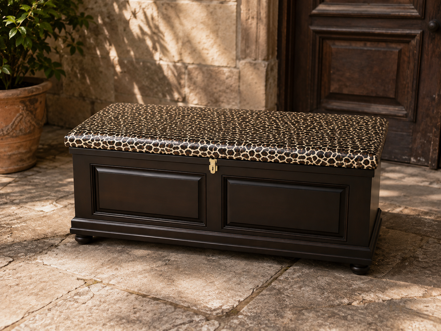 Amabala Kist shown in a stone courtyard setting, leopard-print lid and brass latch