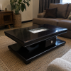 Keystone coffee table shown in a living room, showing the arched pedestal base and drawer